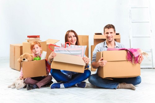 Movers carrying office furniture through a Camden building with narrow access