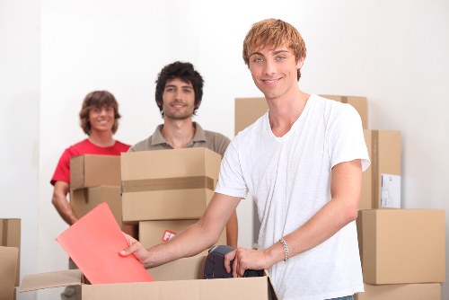 Removal team carrying furniture near a Camden townhouse